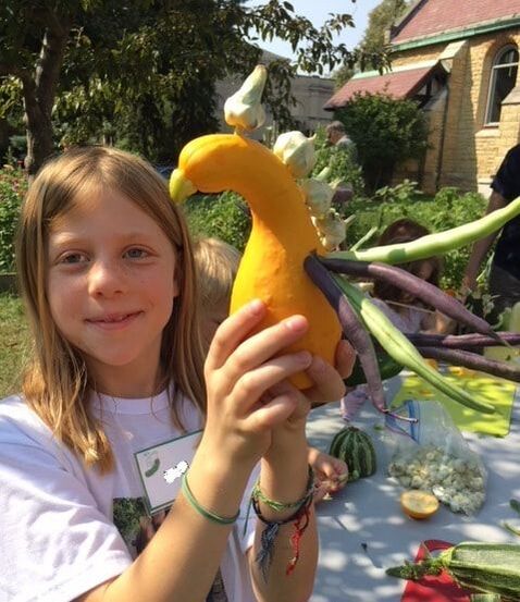child with vegetable sculpture in children's garden