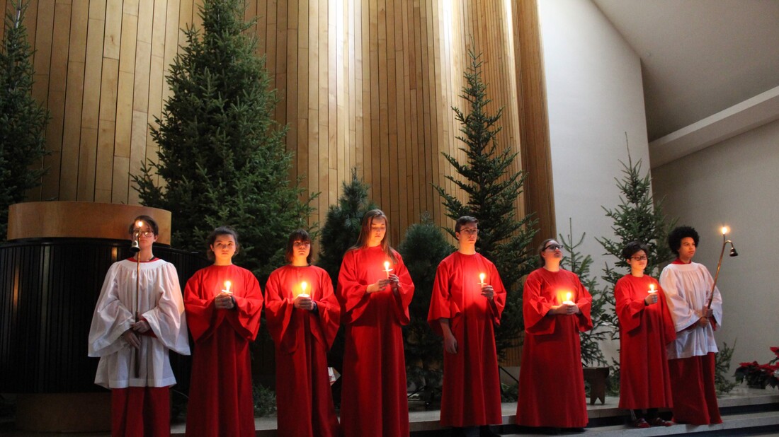 Acolytes holding candles in the sanctuary